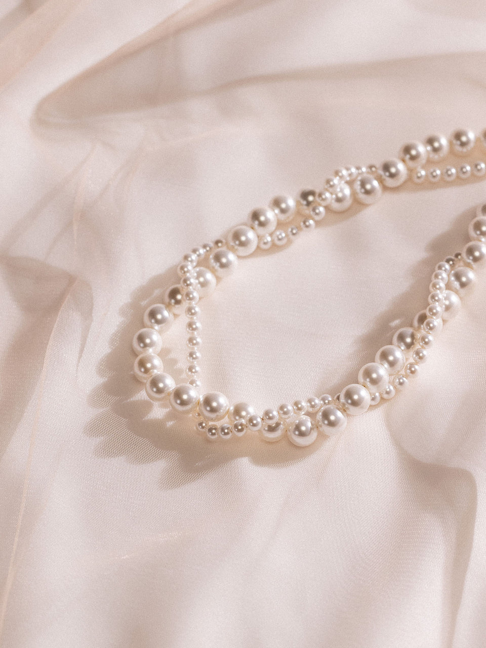 Pearl Elegance Perlenkette aus Muschelperlen auf zartem Stoff, PURELEI feminine Eleganz mit Island-Spirit.