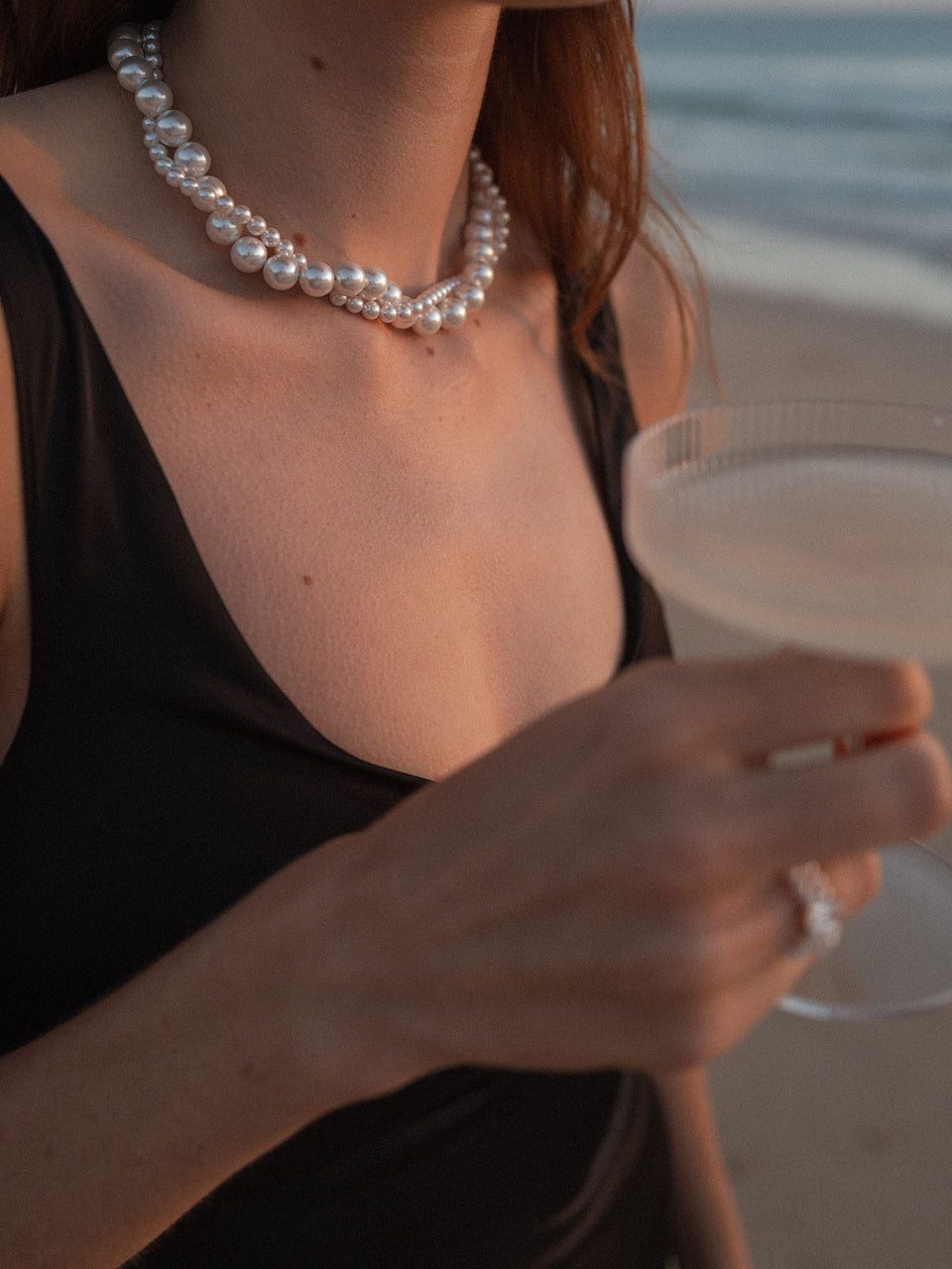 Pearl Elegance Perlenkette von PURELEI, doppellagig mit großen und kleinen Muschelperlen, eleganter Look am Strand.
