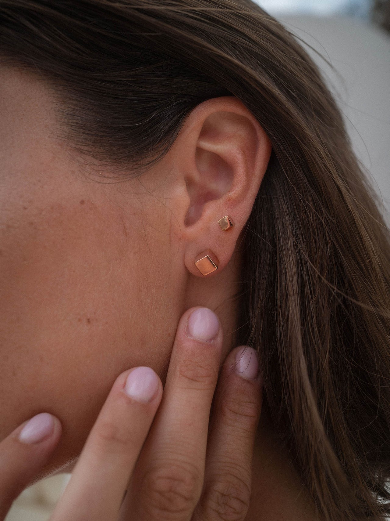 PURELEI Dice Ohrringe Set in Roségold, minimalistisches Würfeldesign, fein und elegant am Ohr getragen.