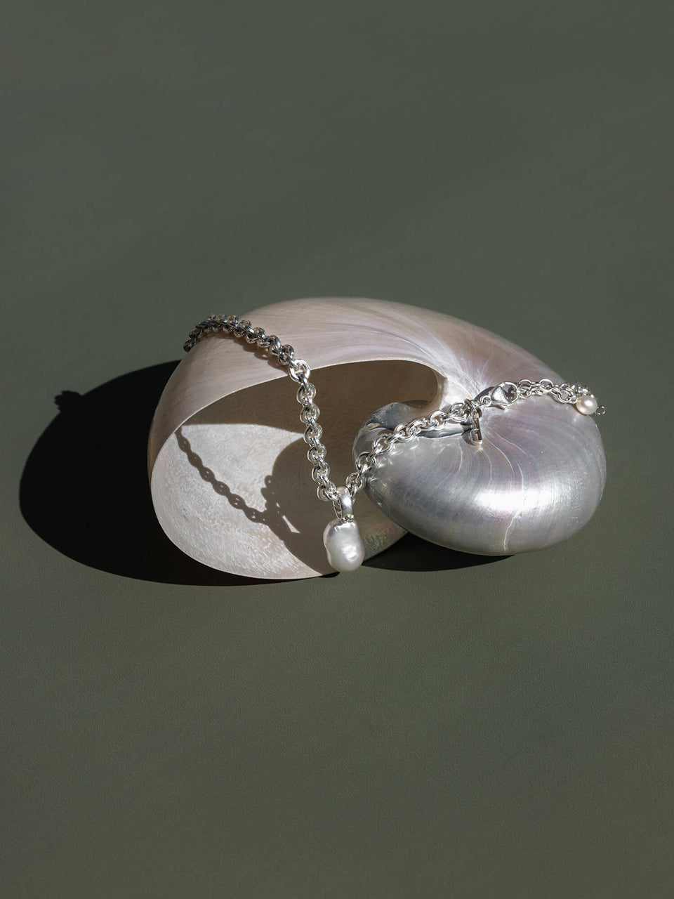 Dream Charm mit Perle von PURELEI, Silber mit organischer Barockperle auf sanftem, grünem Hintergrund