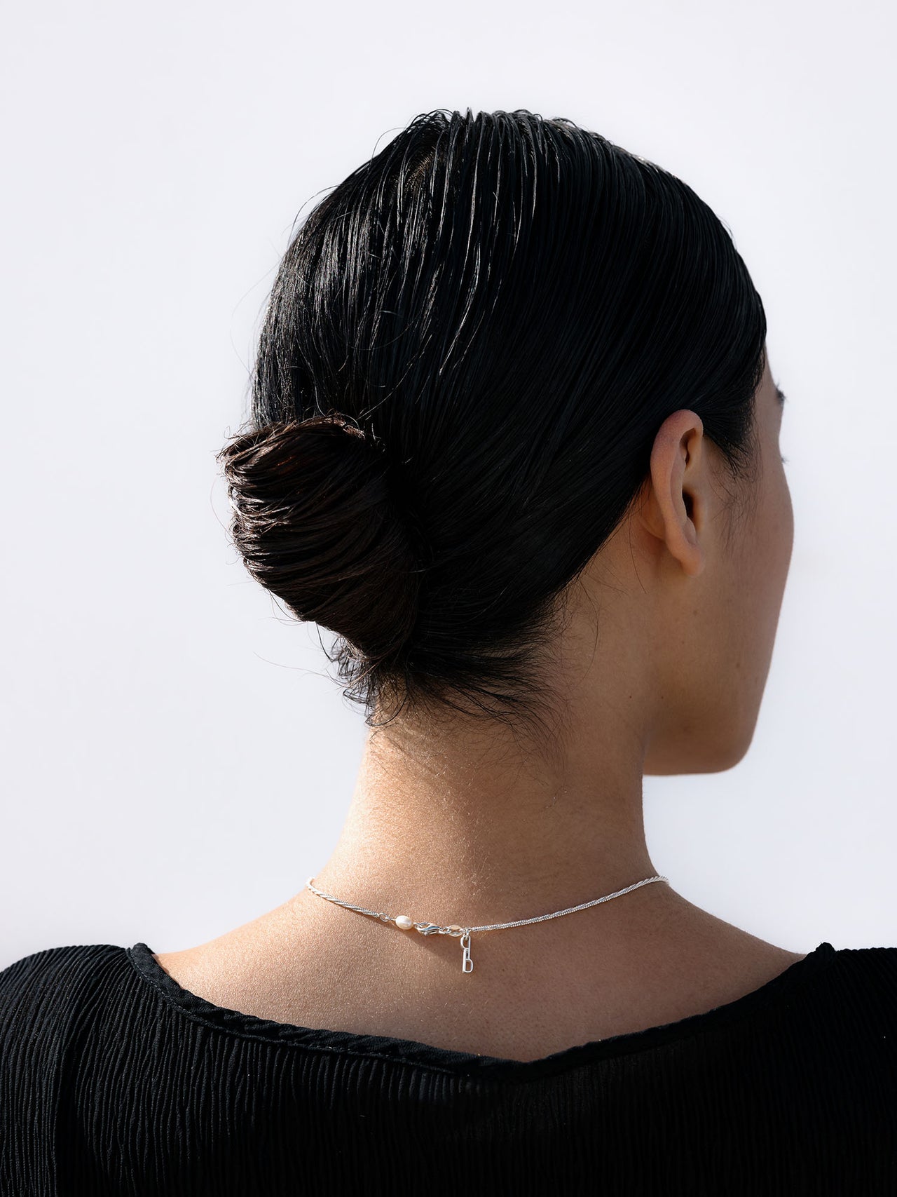 Symphony Kette aus recyceltem Silber mit schimmernder Süßwasserperle am eingerollten Hals – elegant, pure PURELEI Ästhetik.
