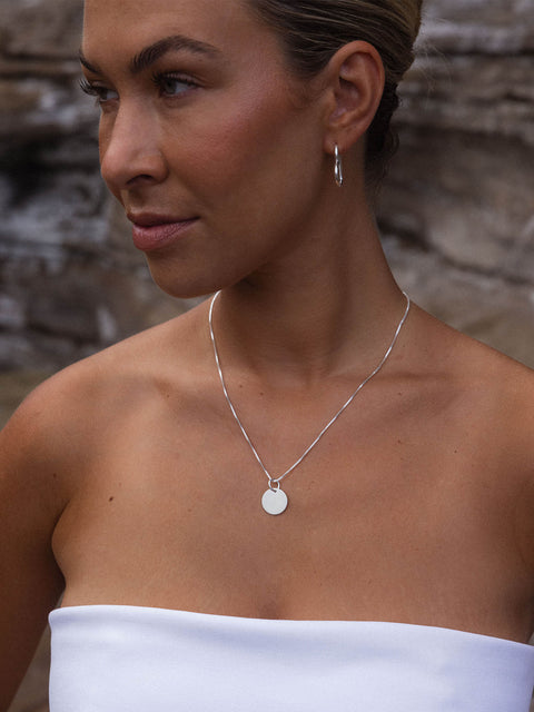 Purelei Perfection Charm aus recyceltem Silber, schlicht und elegant am Hals getragen, feminine Insel-Ästhetik.