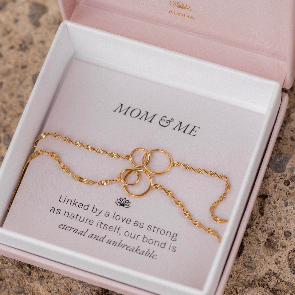 PURELEI Armband Set Kekahi mit goldenen, ineinander greifenden Ringen in Schmuckbox, elegant und symbolisch.