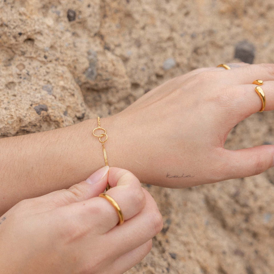 PURELEI Armband Set Kekahi aus 18K Gold Edelstahl mit ineinandergreifenden Ringen, elegant und feminin getragen am Handgelenk.