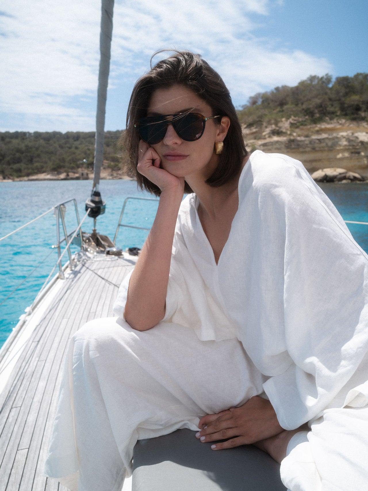Palm Beach Sonnenbrille von PURELEI in braunem Schildpatt mit goldenen Bügeln, elegant am Segelboot getragen.