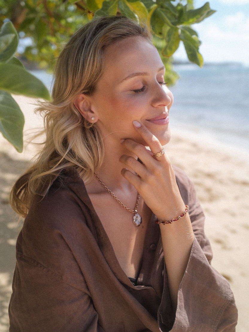 Elegante PURELEI Kette und Armband in Gold, getragen am Strand, mit tropischer Leichtigkeit.