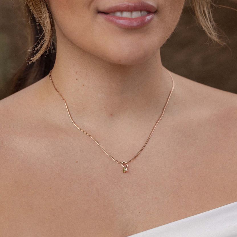 Silberne Kette mit zartem Anhänger, getragen auf nackter Haut, PURELEI inspiriert.