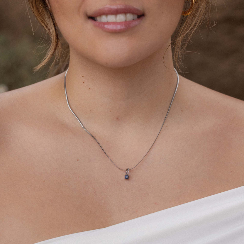 Silberne Kette mit zartem Anhänger, getragen mit eleganter Bluse – PURELEI Stil.