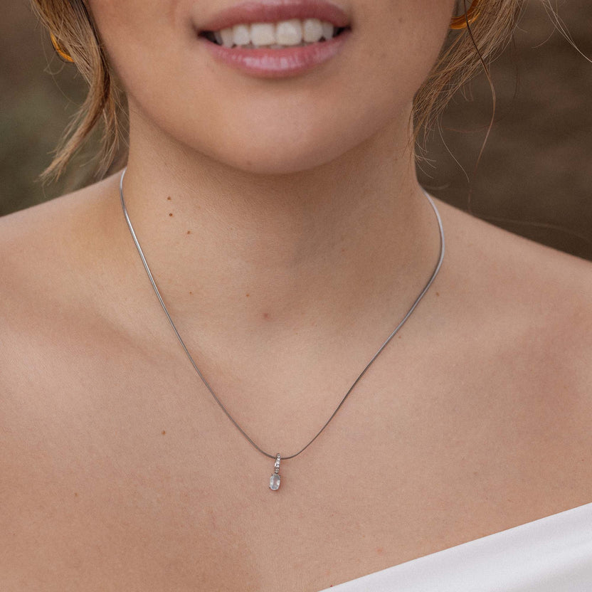 Silberne Kette mit zartem Anhänger, getragen auf der Haut, PURELEI inspiriert.