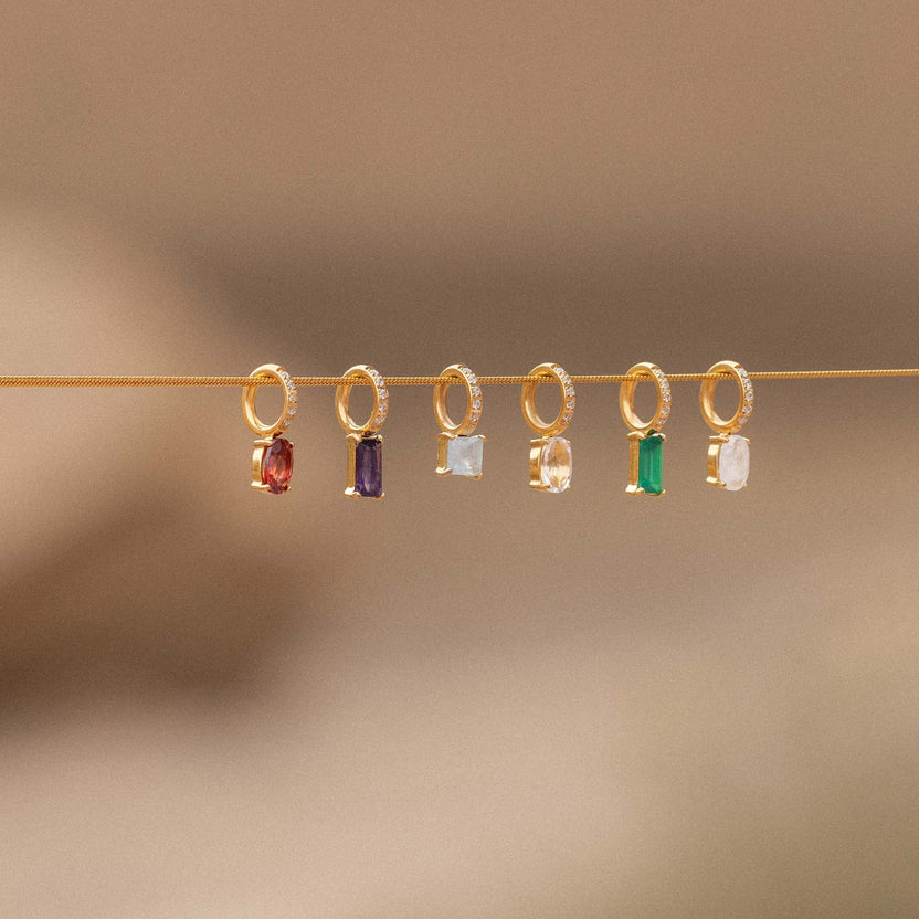 PURELEI goldene Ohrringe mit bunten Steinen, elegant und modern, auf feinem Hintergrund.