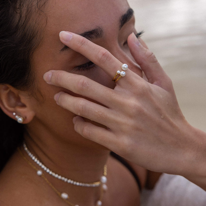 Zarter Ring mit Perlen und goldfarbenem Band, getragen von einer Frau, PURELEI.