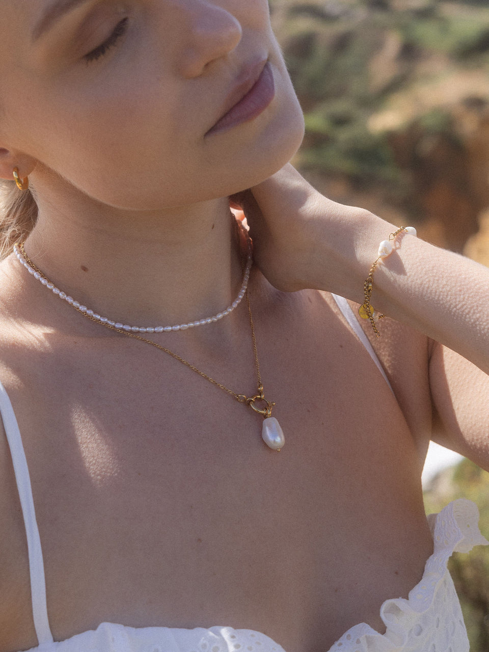 PURELEI Lokahi Charm Kette aus vergoldetem Edelstahl mit Perlenanhänger, zart und elegant, am Hals getragen.