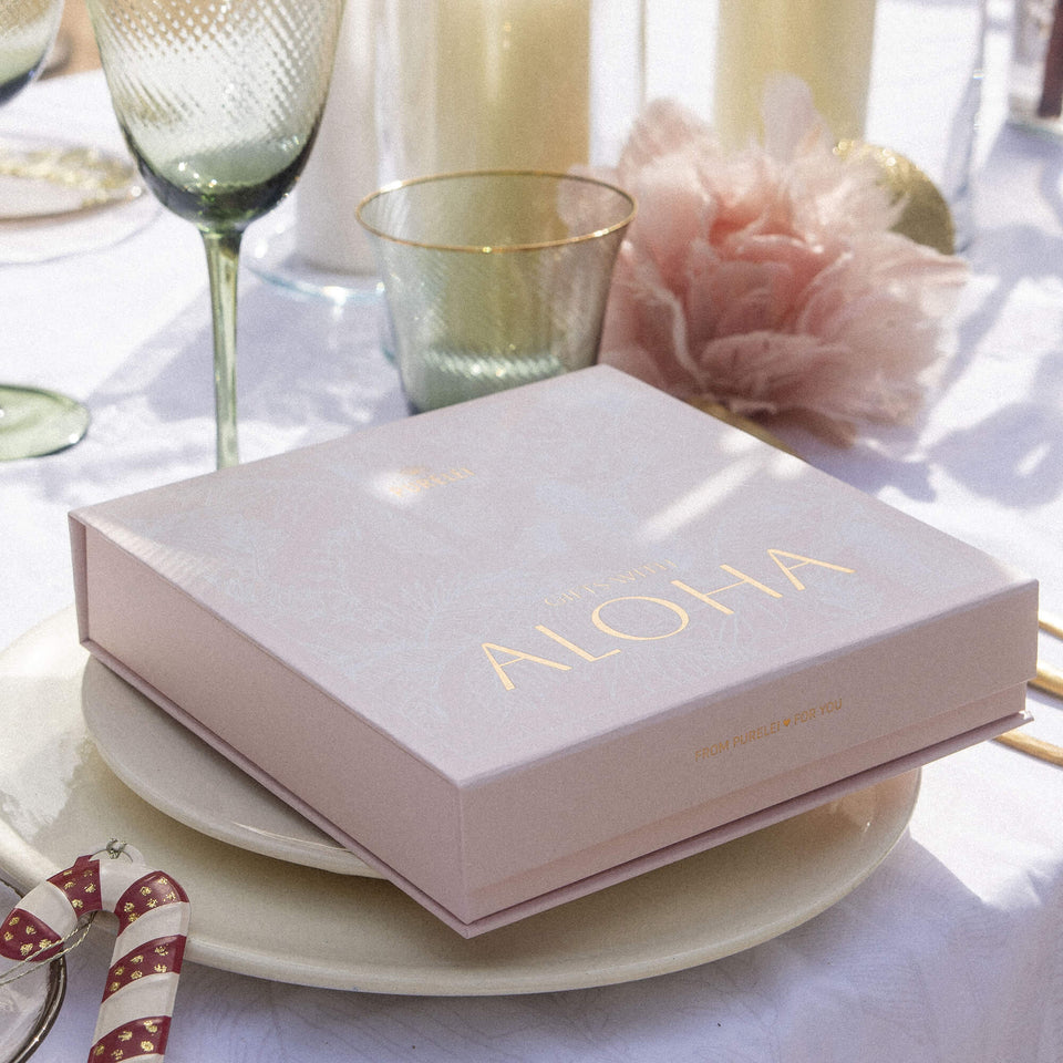 Aloha Geschenkbox für 4 Produkte in zartem Rosé mit tropischem Weißdruck und goldveredelter Schrift von PURELEI