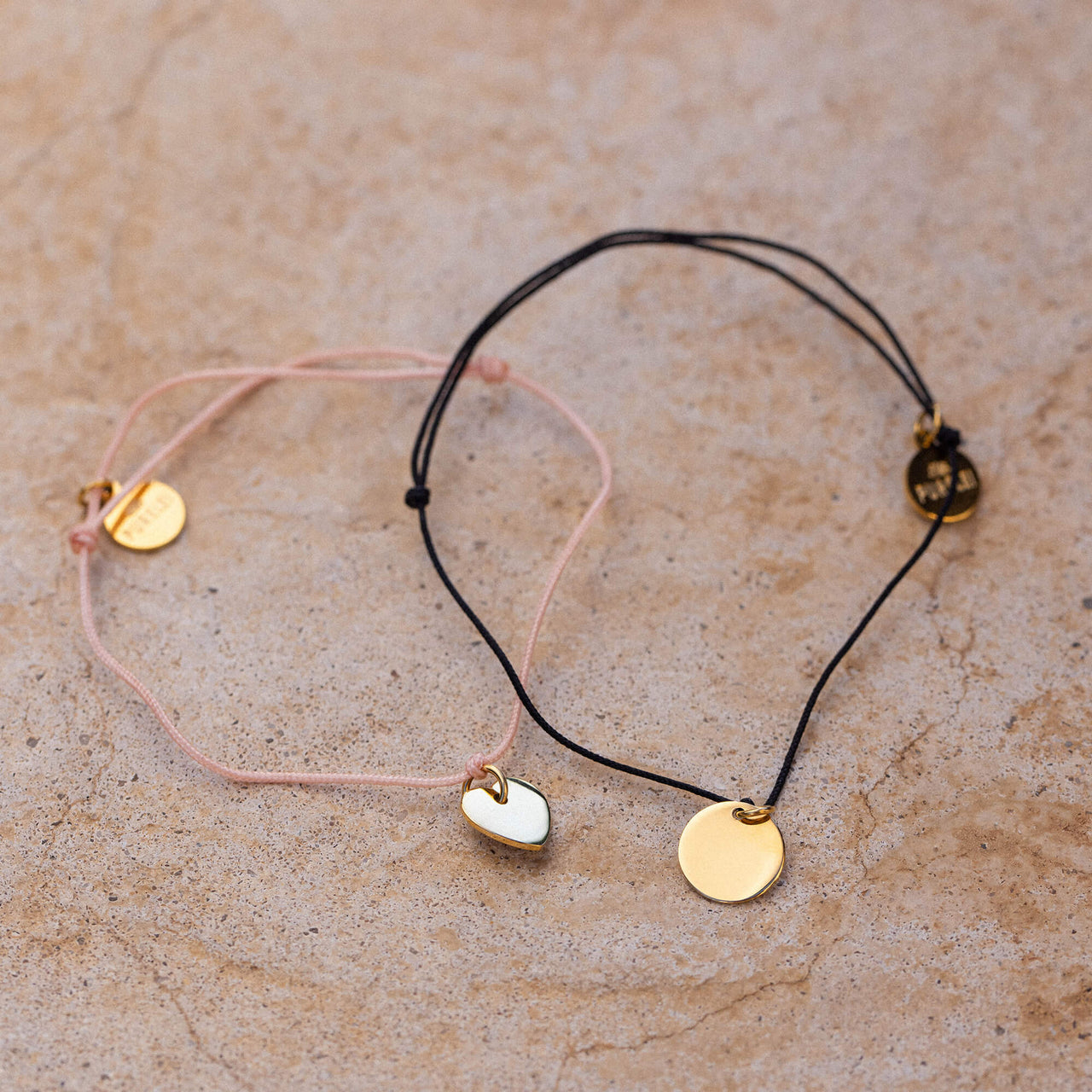 Fate Armband Set von PURELEI mit rosafarbenem Nylon und Herzanhänger, schwarzem Nylon mit goldfarbenem Coin, elegant.