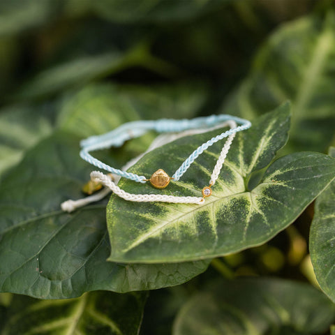 Blue Ocean Armband Set von PURELEI mit Muschel und Zirkonia, nickelfrei, elegant auf grünem Blatt inszeniert
