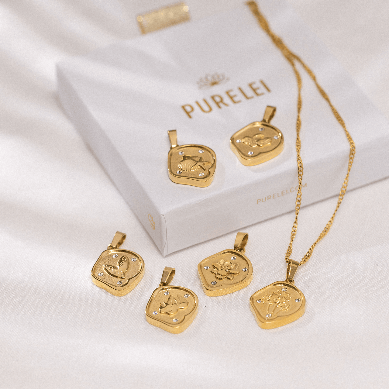 Wave Coin Charm von PURELEI, goldener asymmetrischer Anhänger mit Wellenmotiv und funkelnden Zirkonia, elegant und feminin.