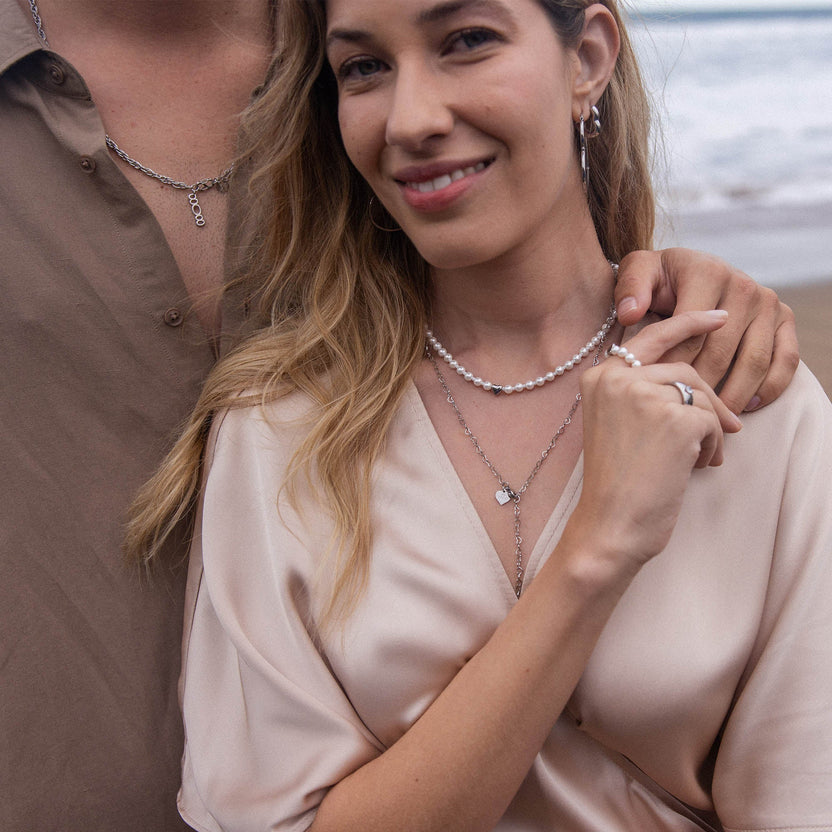 Zarte PURELEI Ketten aus Silber und Perlen, elegant getragen am Strand.