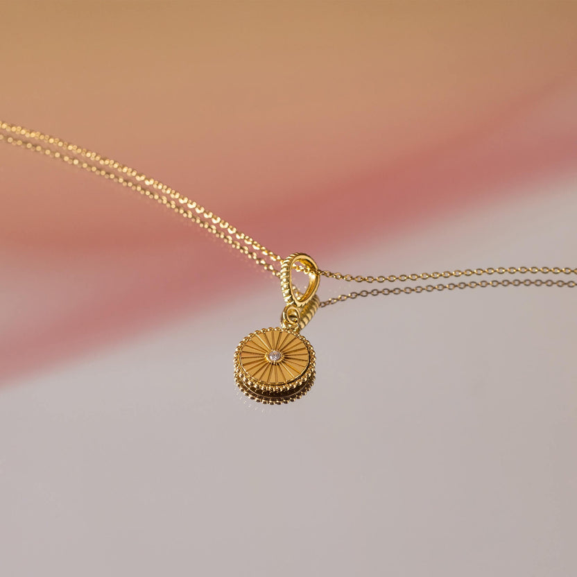 Starlet Kette (Fire) von PURELEI, doppelte goldfarbene Kette mit strahlenförmigem Coin-Anhänger, elegant und feminin.