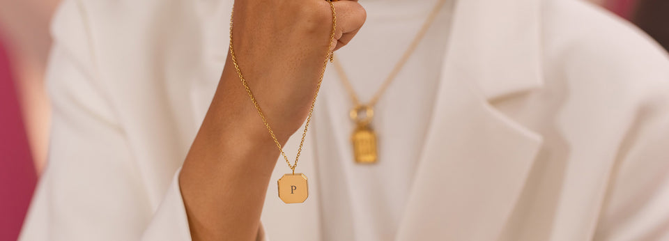 PURELEI Gravur-Service Amulett Heartbeat Kette in Gold, edel und feminin, minimalistisch am Handgelenk getragen.