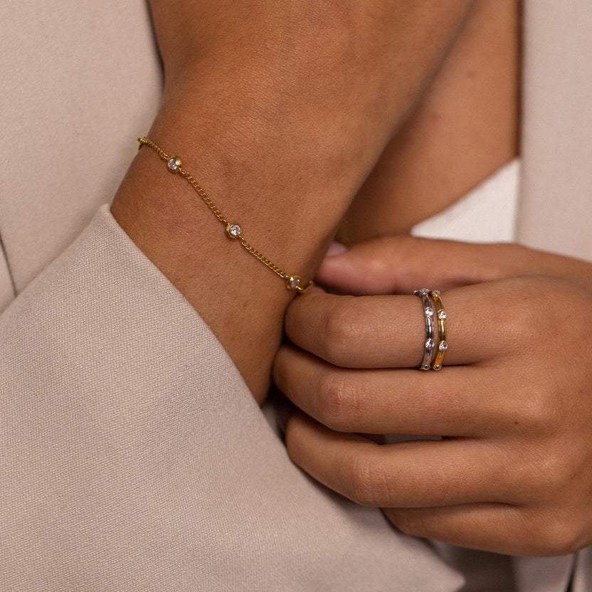 Roségoldenes Armband mit funkelnden Details, getragen mit Ringen von PURELEI.