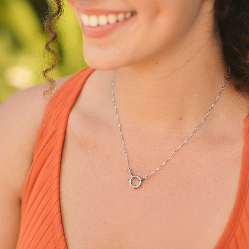 Silberne, nickelfreie Lokahi Charm Kette von PURELEI mit filigraner Kette, getragen im warmen Tageslicht.