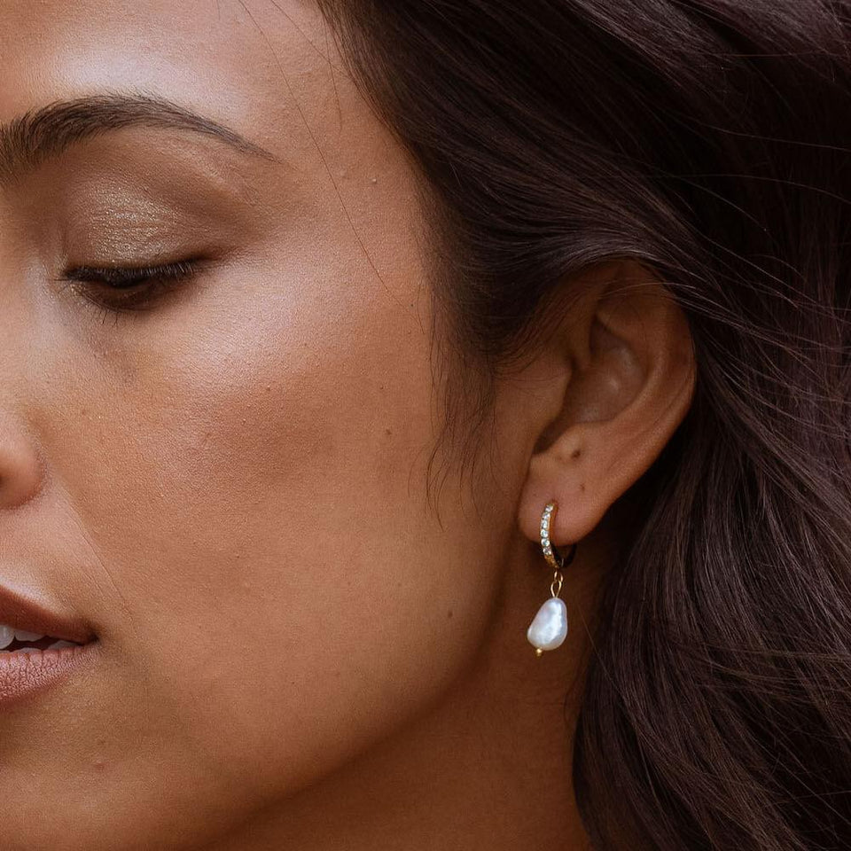 PURELEI Malahi Ohrringe mit 18K Gold, Zirkonia und Süßwasserperle, elegant am Ohr getragen, feminine Leichtigkeit.
