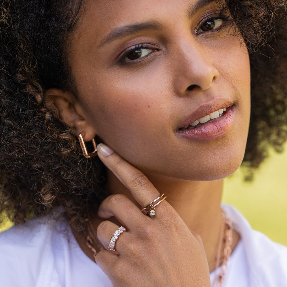 Powder Ring von PURELEI in Roségold mit asymmetrischen Zirkonia-Steinen, elegant und feminin am Finger getragen.