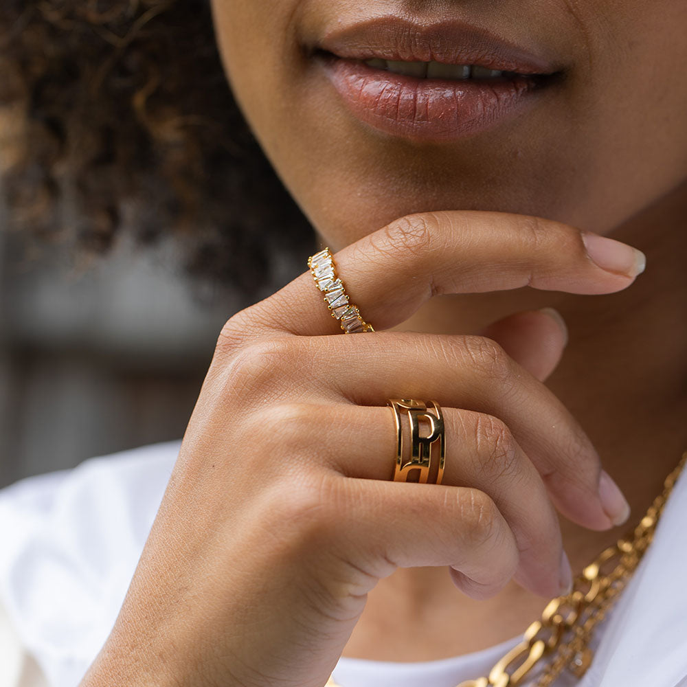 PURELEI Powder Ring aus 18K Gold mit asymmetrischen Zirkonia-Steinen, elegant und feminin getragen am Finger.