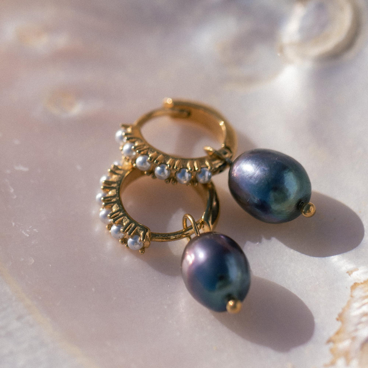 Pearly Perlenohrringe von PURELEI, goldene Creolen mit weißen Glas- und blau-lila Keshiperlen, elegant und feminin.