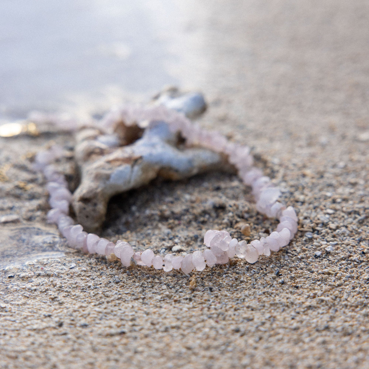 PURELEI Rosenquarz Kette mit zarten rosa Steinen am Strand, natürlich und elegant, nickelfrei und wasserfest.
