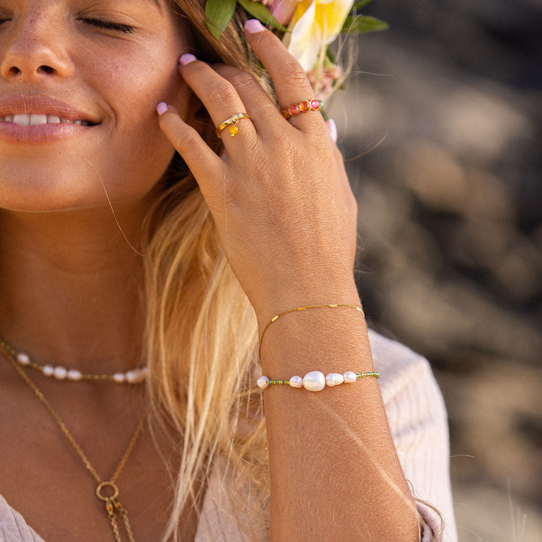 Blissful Armband von PURELEI mit Süßwasser- und Glasperlen in Blau und Gelb, natürlich elegant, am Handgelenk getragen