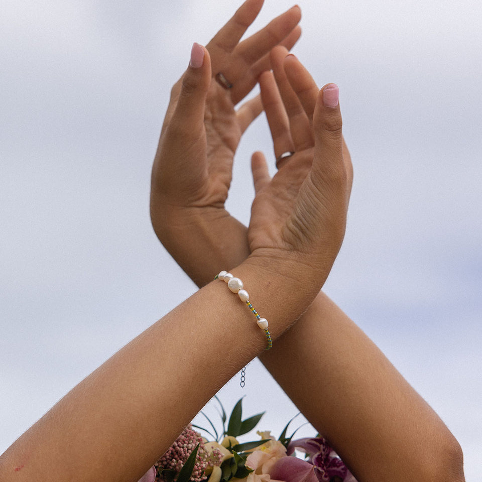 Blissful Armband von PURELEI mit Süßwasser- und Glasperlen in Blau-Gelb, elegant am Handgelenk getragen.