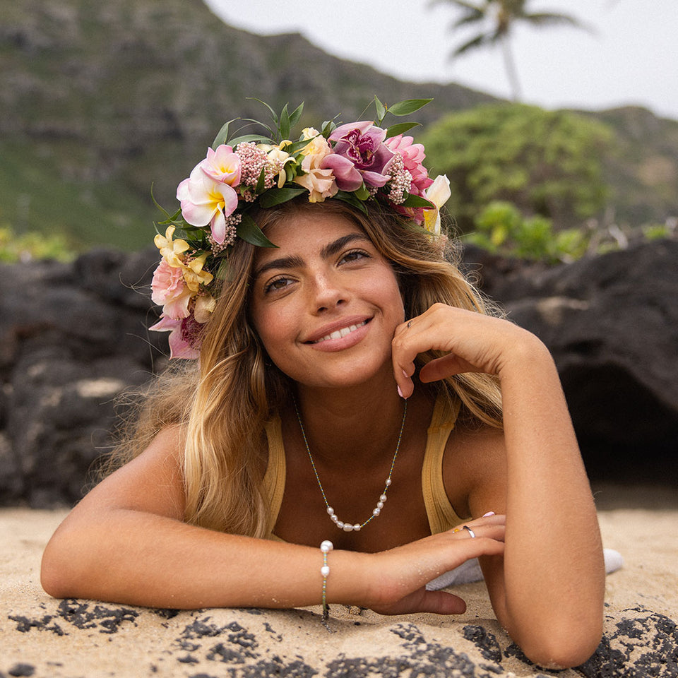Blissful Armband von PURELEI mit blau-gelben Glas- und Süßwasserperlen, am Sandstrand, feminine Island-Vibes.