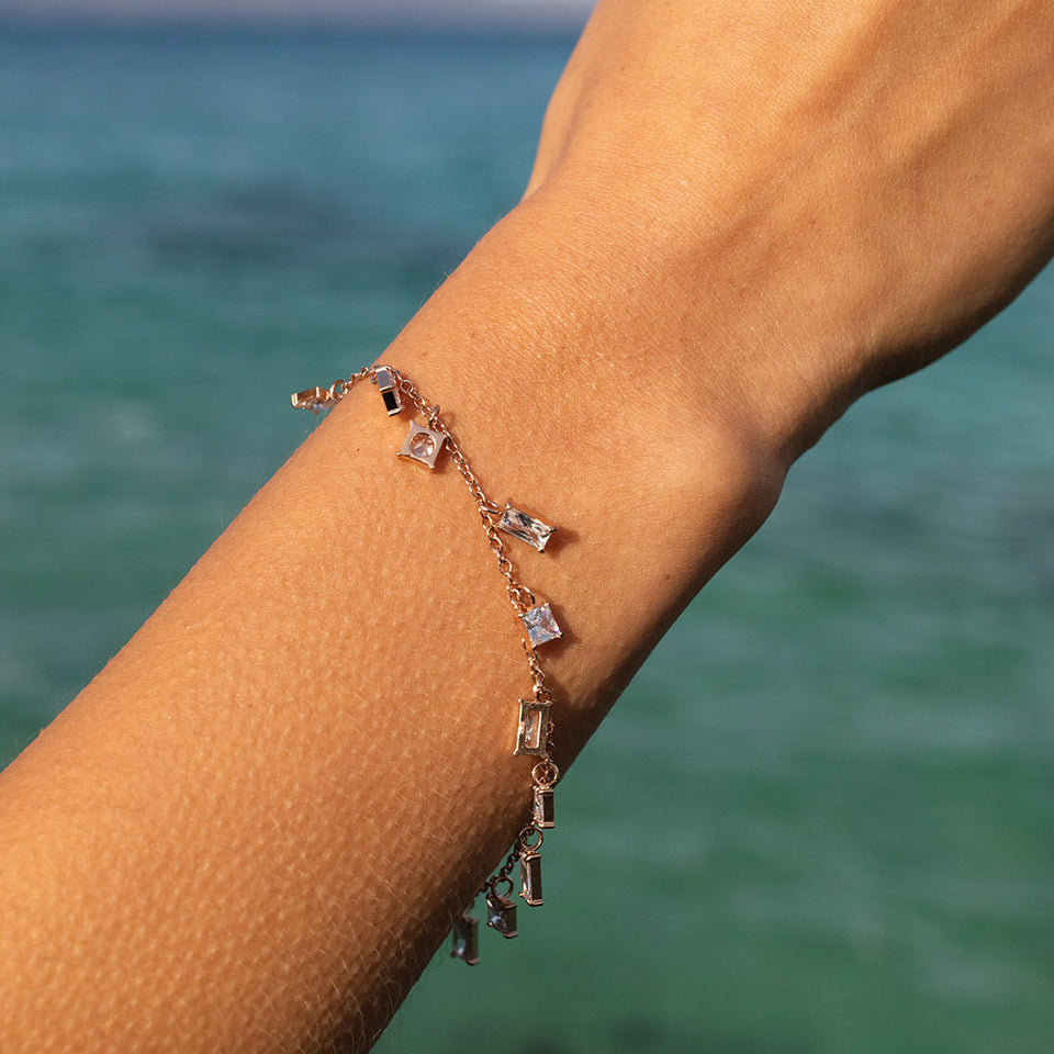 Powder Armband in Roségold mit funkelnden Zirkonia, elegant am Handgelenk vor Meeresszenerie, PURELEI.