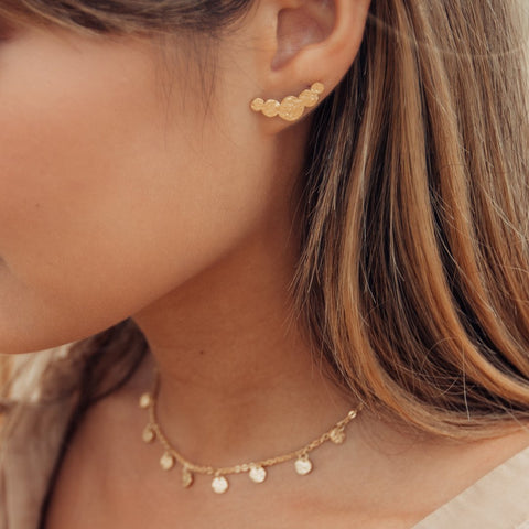 Malihini Ohrringe aus 18K Gold mit geprägten Coins, elegant getragen für feminine PURELEI Island-Spirit Ästhetik.