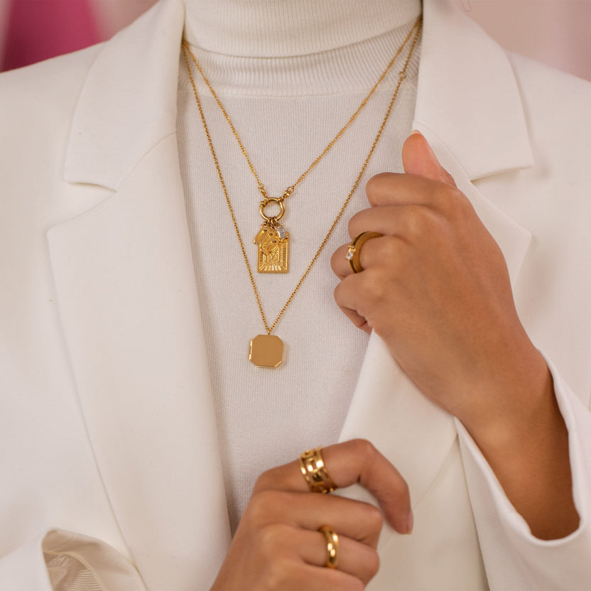 Roségoldene Ketten mit Anhängern, elegant getragen unter einem weißen Blazer – PURELEI Stil.