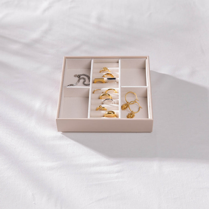 Elegante Ringe und Ohrringe in einer stilvollen Box von PURELEI, auf sanftem Stoff arrangiert.